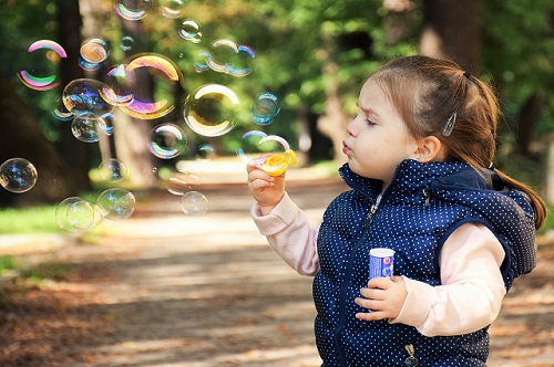 child blowing bubbles