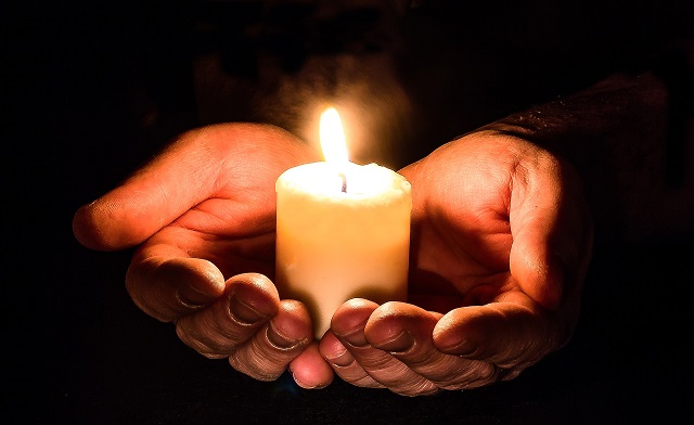 lighted candle in black background