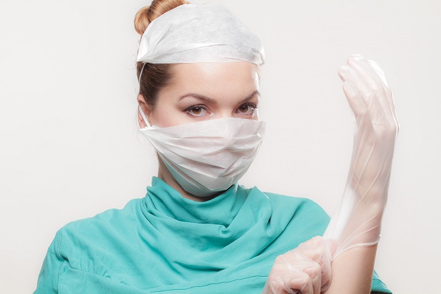 female doctor fitting gloves on