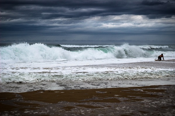 ocean on a cloudy day with a person on the waves