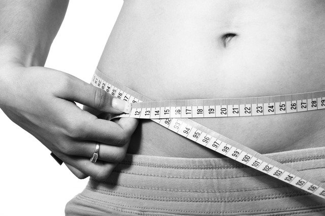 woman measuring her body with a tape rule