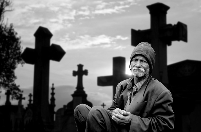 sad man sitting in the cementary